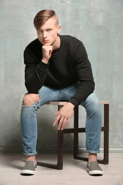 Man sitting near textured wall — Stock Photo, Image