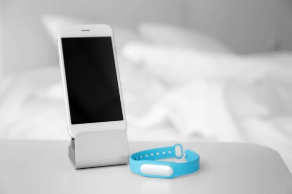 Mobile phone e sleep tracker sul tavolo in camera da letto — Foto Stock