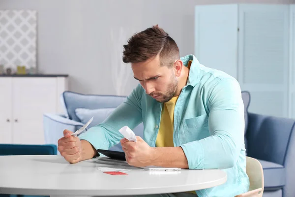 Young man calculating taxes — Stock Photo, Image