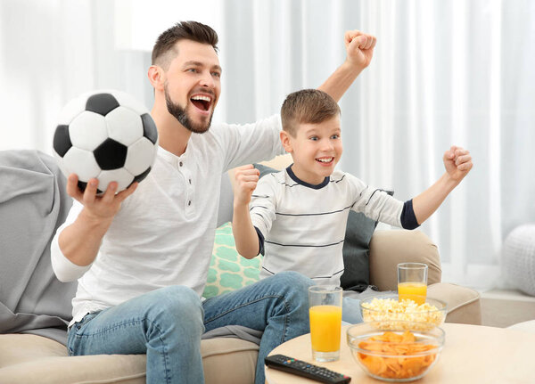 Отец и сын смотрят футбол
