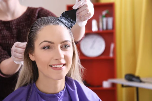Молодая женщина окрашивает волосы — стоковое фото