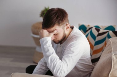 Genç adam evde baş ağrısı çekiyor.