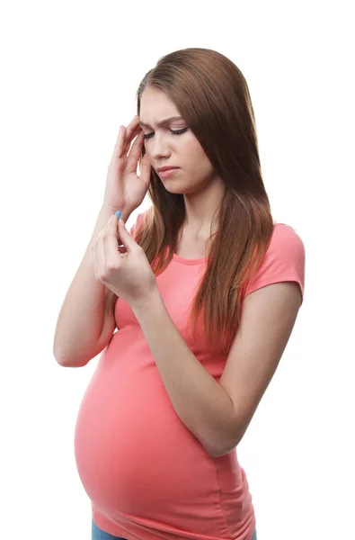 Mulher grávida tomando pílula contra dores de cabeça em fundo branco — Fotografia de Stock