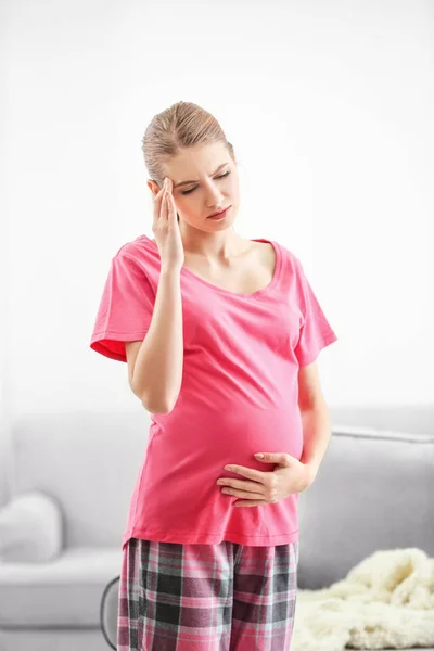 Gravid kvinde lider af hovedpine derhjemme - Stock-foto