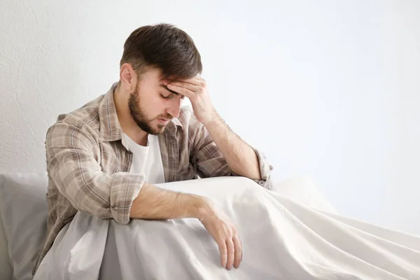 Joven con dolor de cabeza sentado en la cama —  Fotos de Stock