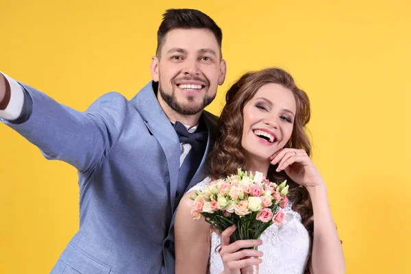 Casal feliz fazendo selfie no fundo da cor — Fotografia de Stock