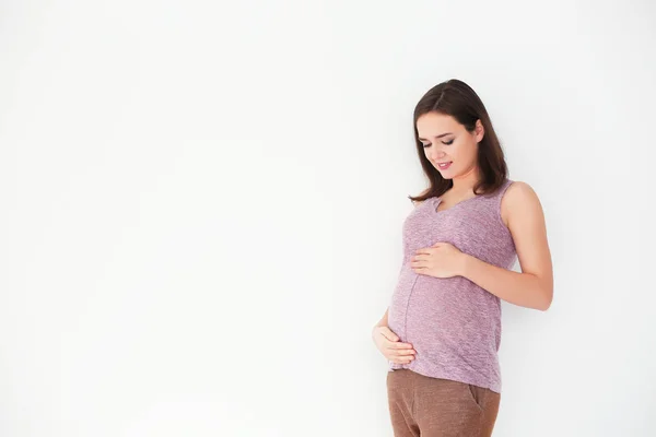 Hermosa mujer embarazada sobre fondo claro — Foto de Stock