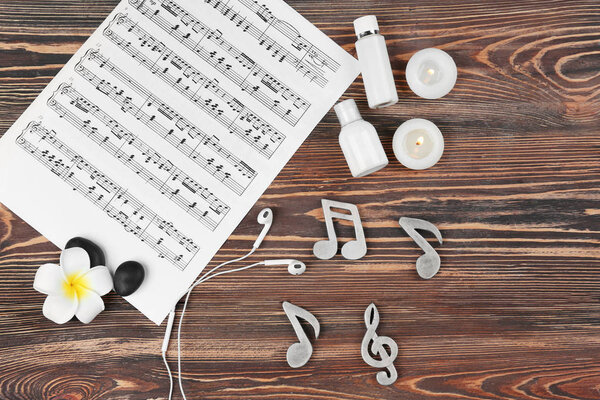 Состав музыкальных листов и спа-принадлежностей на деревянном фоне
