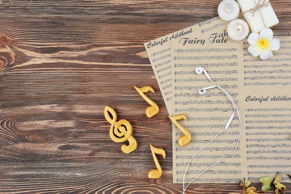 Composition of music sheets and spa supplies on wooden background — Stock Photo, Image