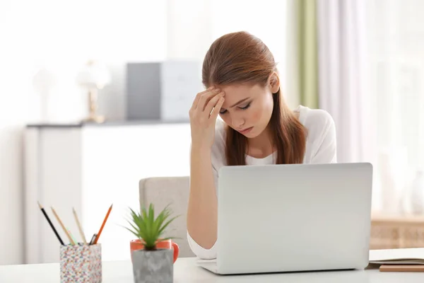 Schöne junge Frau leidet unter Kopfschmerzen, während sie im Büro arbeitet — Stockfoto