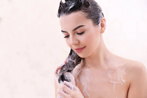 Beautiful young woman washing hair — Stock Photo, Image