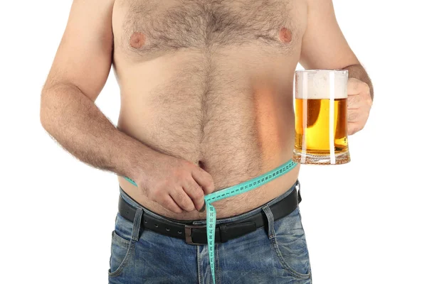 Uomo che misura la pancia e tiene il bicchiere di birra — Foto Stock