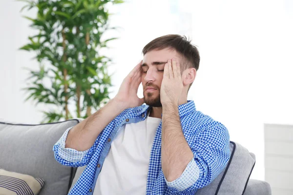 Ung man som lider av huvudvärk hemma — Stockfoto