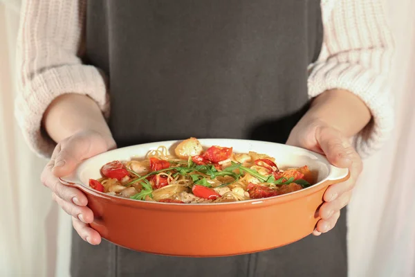 Woman holding baking dish with tasty chicken spaghetti — Stock Photo, Image