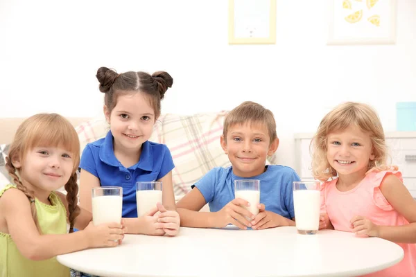 快乐的孩子在餐桌上喝杯牛奶 — 图库照片