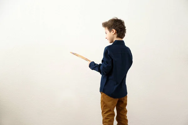 Söt liten artist nära ljus vägg — Stockfoto
