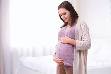 Evdeki güzel hamile kadın.