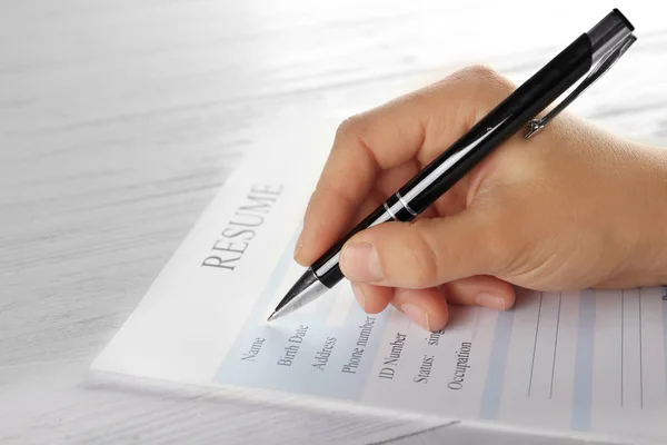 Female hand filling in resume — Stock Photo, Image