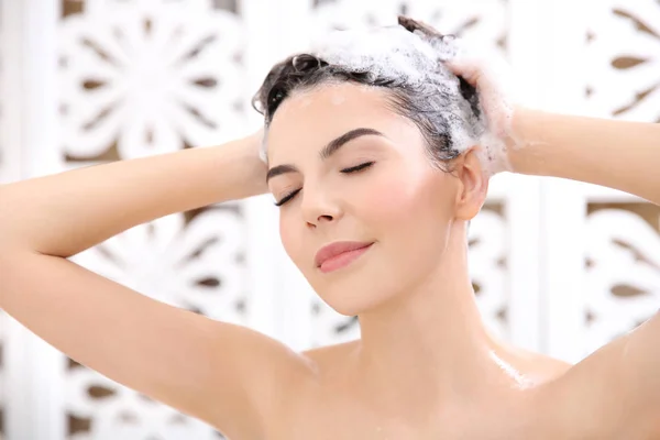 Beautiful young woman washing hair — Stock Photo, Image