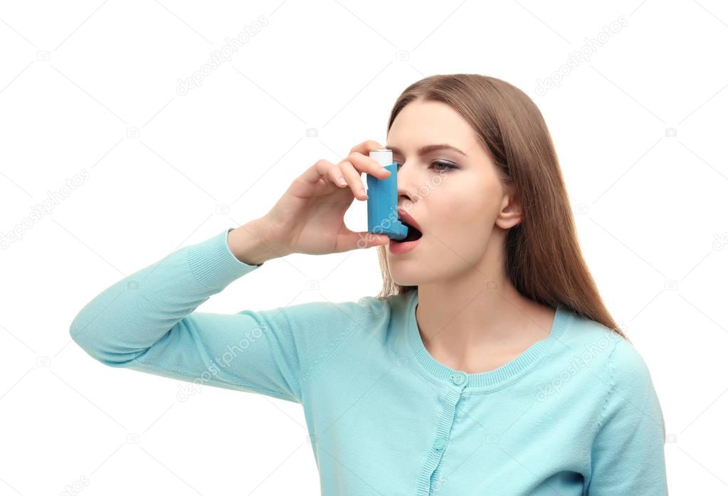 Young woman using asthma inhaler 