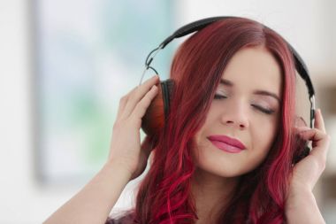 Bulanık arka planda müzik dinlemek boyalı saçlı güzel genç kadın