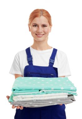 Beyaz arka plan üzerinde katlanmış yatak giysileri ile güzel kadın