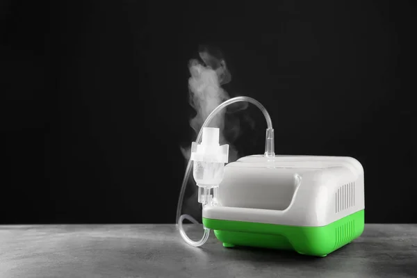 Nebulizer kompresor pada tabel dengan latar belakang hitam — Stok Foto