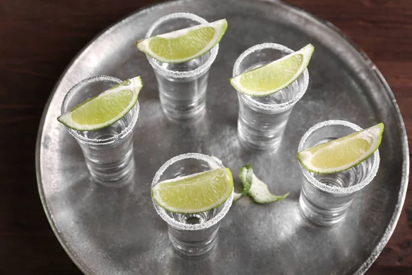 Tequila Shots mit saftigen Limettenscheiben und Salz auf Tablett — Stockfoto