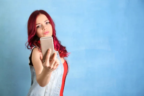 Bella giovane donna con i capelli tinti prendendo selfie su sfondo di colore — Foto Stock