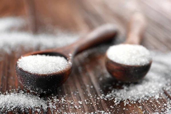 Weißer Sand Zucker in Löffeln auf Holzgrund — Stockfoto