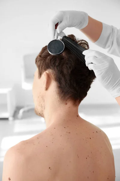 Dermatoloog met Vergrootglas examencommissie patiënt in kliniek — Stockfoto