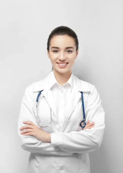 Hermoso médico joven sobre fondo claro — Foto de Stock