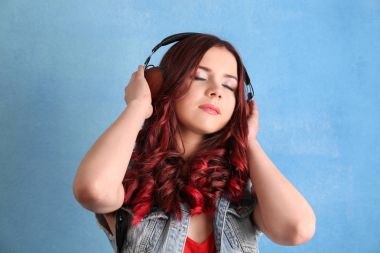 Renk arka plan üzerinde müzik dinlemek boyalı saçlı güzel genç kadın