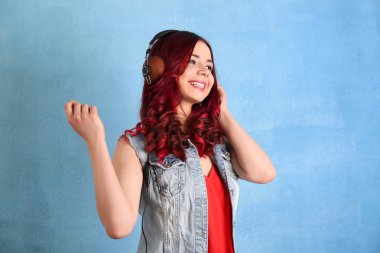 Renk arka plan üzerinde müzik dinlemek boyalı saçlı güzel genç kadın