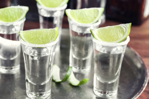 Tequila Shots mit saftigen Limettenscheiben und Salz auf Tablett — Stockfoto