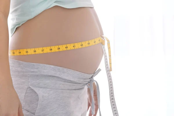 Schwangere mit Maßband am Bauch, Nahaufnahme — Stockfoto