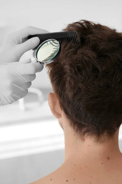 Dermatoloog met Vergrootglas examencommissie patiënt in kliniek, close-up — Stockfoto
