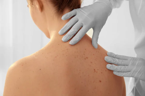 Dermatolog klinikteki hastayı muayene ediyor.