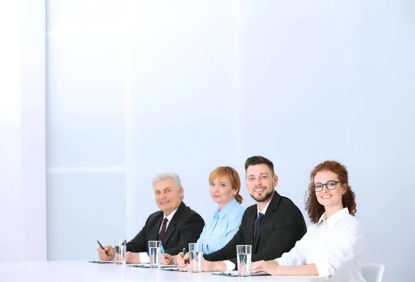 Gruppe Von Vier Geschäftsleuten Eleganten Anzügen Sitzt Arbeitstisch Hellen Auditorium — Stockfoto