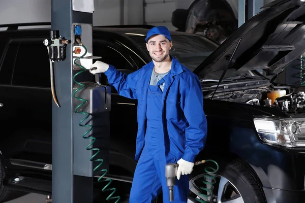 Mechanic standing near auto lift — Stock Photo, Image