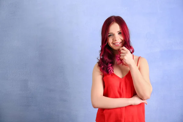 Bella giovane donna con i capelli tinti su sfondo di colore — Foto Stock