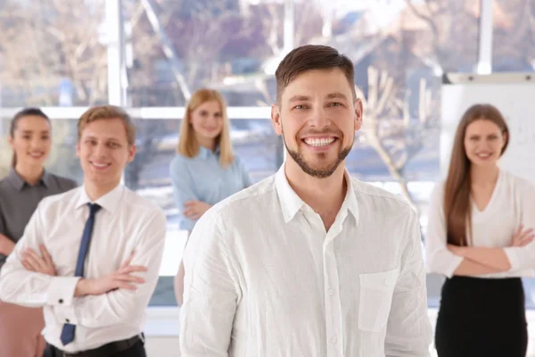 Jonge man met een groep mensen op achtergrond — Stockfoto