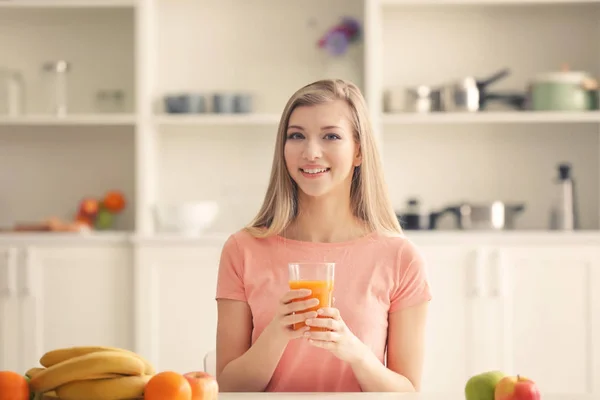 Giovane donna degustazione di succo fresco in cucina — Foto Stock