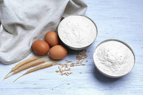 Bowls with flour, eggs and wheat — Stock Photo, Image