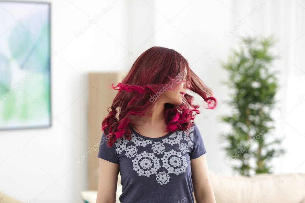 Beautiful young woman with dyed hair at home