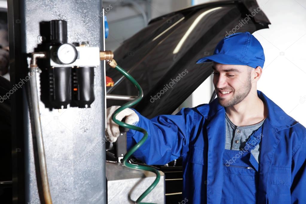 mechanic standing near auto lift 