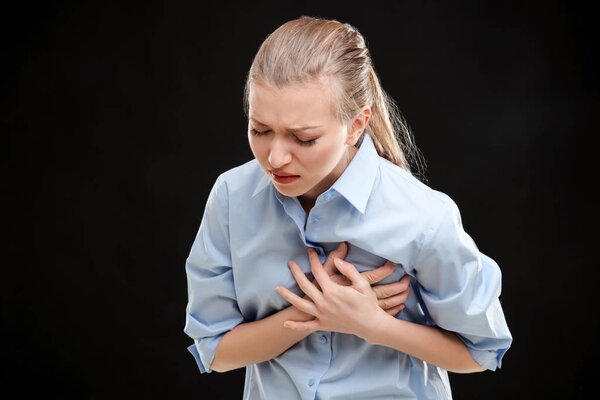 Молодая женщина страдает от боли в груди
