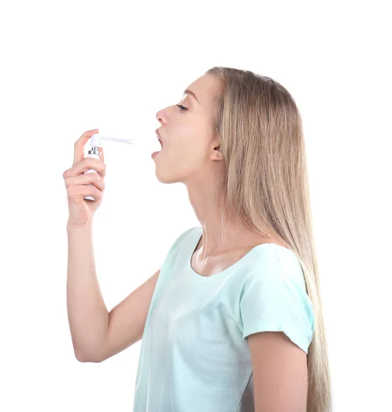 Doente jovem usando spray de garganta no fundo branco — Fotografia de Stock