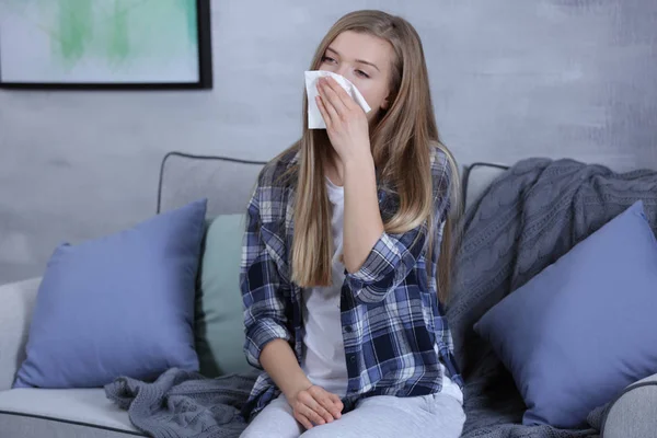 Jovem mulher soprando nariz no tecido em casa — Fotografia de Stock