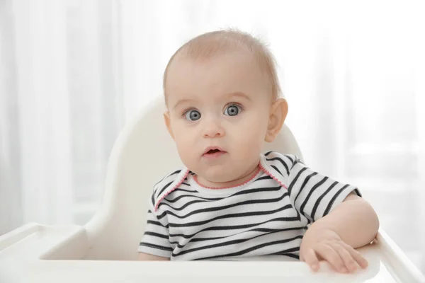 Adorable baby girl sitting in chair for babies — Stock Photo, Image